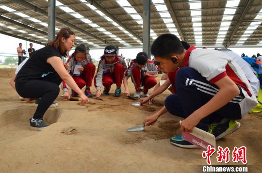 图为考古老师指导学生如何握拿手铲，从中体验考古发掘的过程究竟是怎样的。　周小云　摄